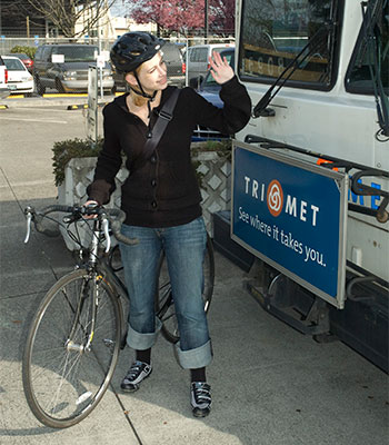 Photo of bicyclist placing bike on bus rack