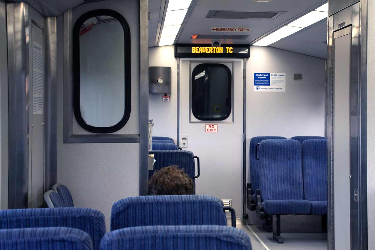 Forward-facing interior shot with seats/riders and ASA screen visible showing stop name