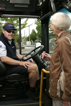 Woman showing pass to operator as she boards the bus