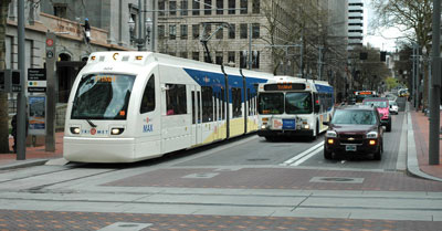 max train, bus and car at intersection