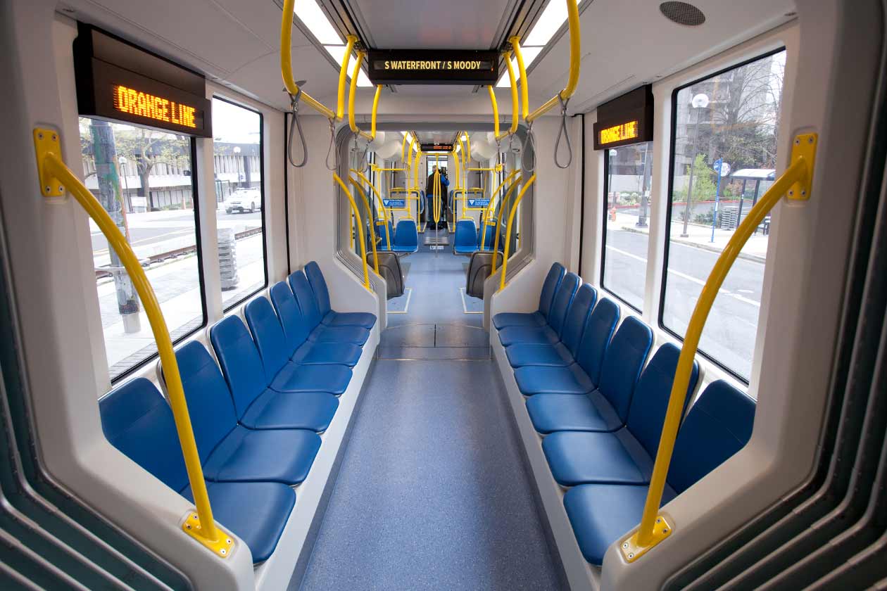 Forward-facing interior shot with seats/riders and ASA screen visible showing stop name.