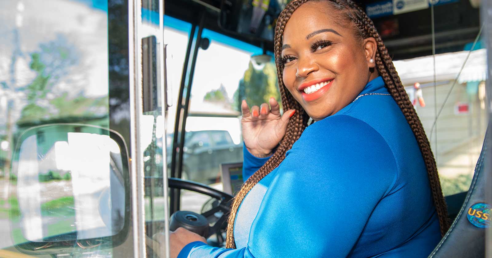 Bus operator smiling and waving